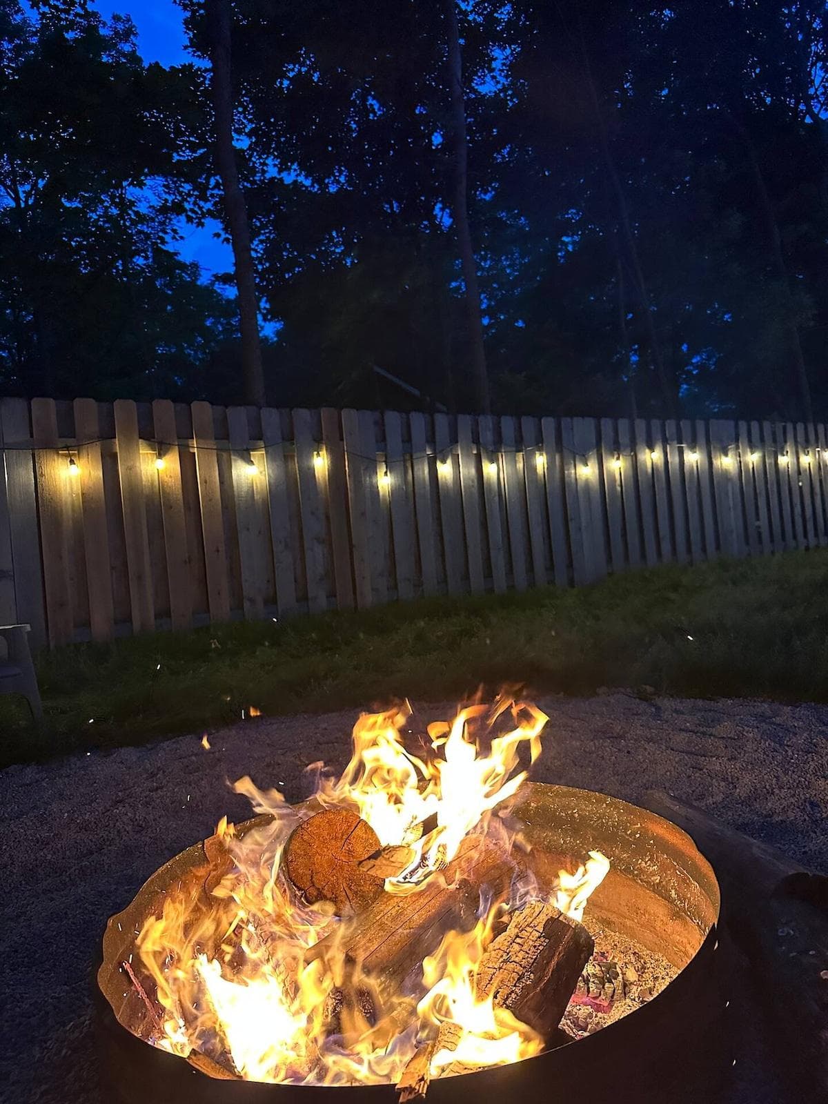 Evenings shine a little brighter here—enjoy the glow of a crackling fire with complimentary firewood, all set against the backdrop of twinkle lights and towering pines.